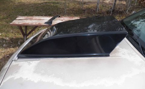1993 Ford Crown Victoria - Aftermarket rear window louvers are placed on a car's trunk for storage.