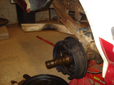1989 Ford F-250 - Close-up of a greasy rear drum brake assembly, likely undergoing maintenance or repair.