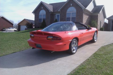 1999 Chevrolet Camaro - The rear view of a red 1999 Chevrolet Camaro shows its spoiler and dual exhaust pipes.