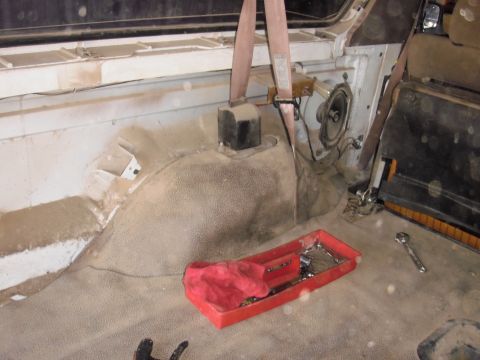 1993 Ford Bronco - Interior of a vehicle with a red toolbox and tools on the floor, showing dust accumulation.