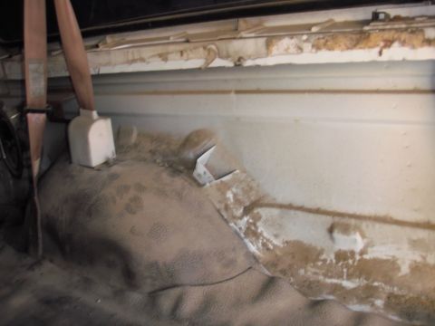 1993 Ford Bronco - The interior of the vehicle shows significant dust and wear on the carpeting and side panels.