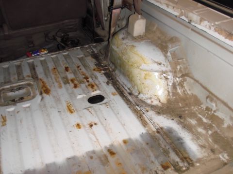 1993 Ford Bronco - The interior cargo area of a vehicle shows signs of wear and dirt.