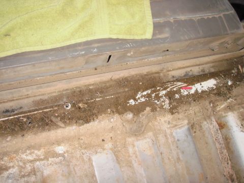 1993 Ford Bronco - The bed liner of a truck is dirty and shows signs of wear. A yellow towel is placed on top.