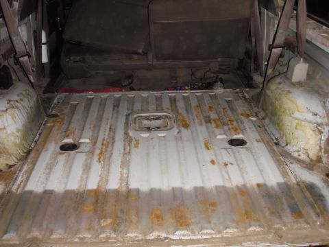 1993 Ford Bronco - The interior cargo area of a vehicle shows a ribbed floor and the rear seat, with some signs of wear and tear.