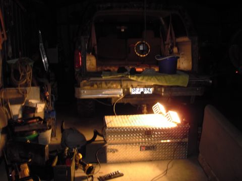 1993 Ford Bronco - The rear of a Ford Bronco is visible in a dimly lit garage, surrounded by tools and equipment.