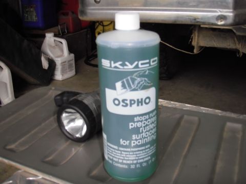 1993 Ford Bronco - A bottle of rust treatment and a flashlight are shown in a garage setting.