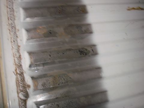 1993 Ford Bronco - Close-up of a dirty and stained white bedliner with visible corrugations.
