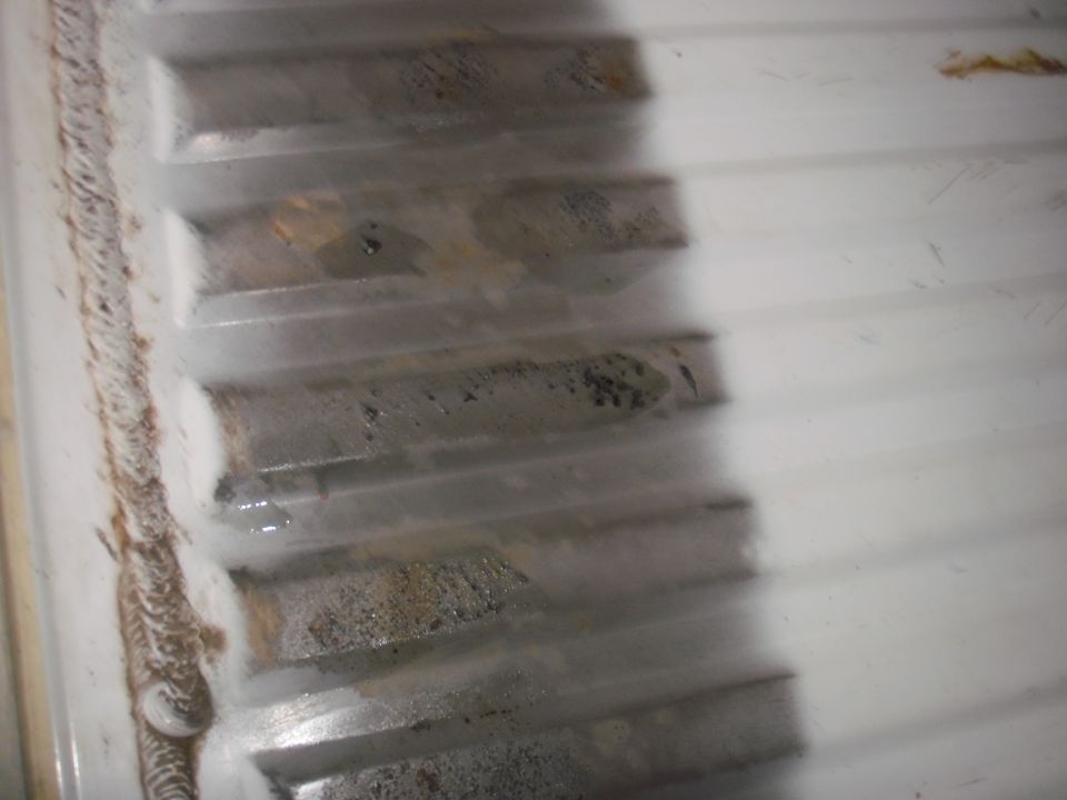 Corrugated white bedliner with rust stains and dirt