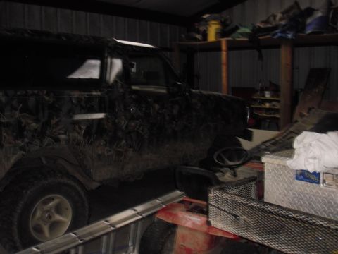 1993 Ford Bronco - Side view of a 1993 Ford Bronco covered in camouflage wrap, parked indoors.