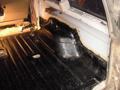 1993 Ford Bronco - The interior of a truck bed is shown with a black coating applied to the floor and sides.