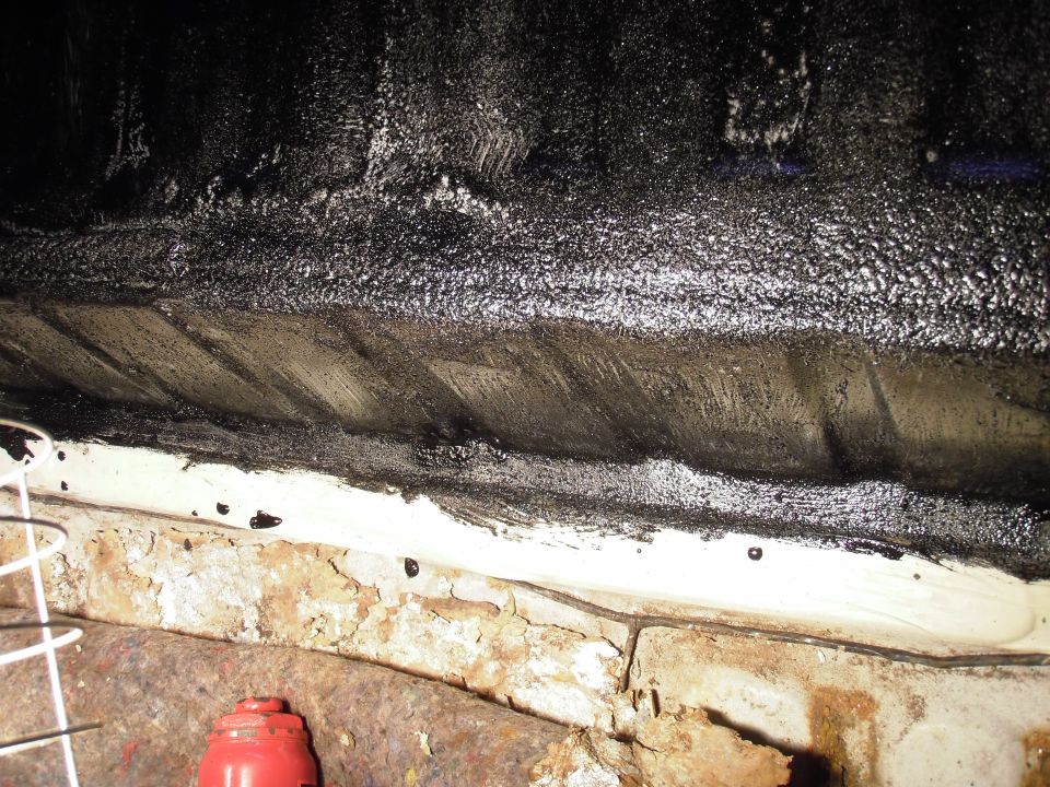 Underbody bedliner with rust and black coating. Supermotors.net logo visible