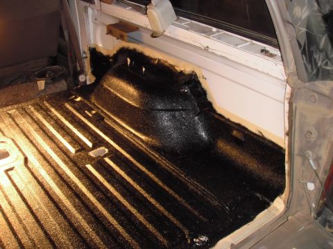 1993 Ford Bronco - Applying black bed liner to the interior of a truck bed.