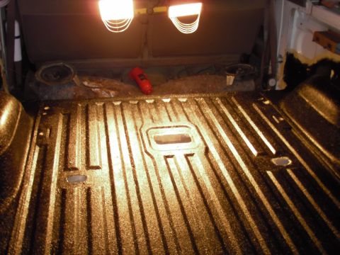1993 Ford Bronco - The textured bedliner of a vehicle interior is illuminated by overhead lights.