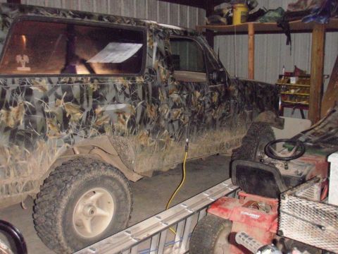 1993 Ford Bronco - Side view of a camouflage-wrapped 1993 Ford Bronco in a garage.