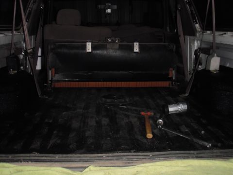 1993 Ford Bronco - Tools are laid out in the bed of a truck, near the folded-down rear seats.