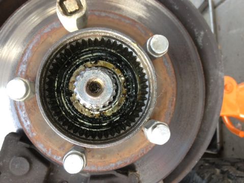 1979 Ford Bronco - Close-up of a vehicle's front hub assembly, showing internal gears and grease.