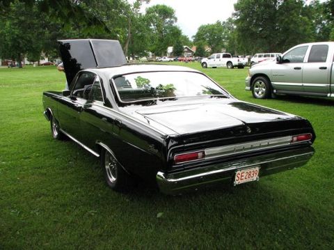 1966 Mercury Comet - A black 1966 Mercury Comet coupe is parked on a grassy lawn with its hood open, showing off its classic design.