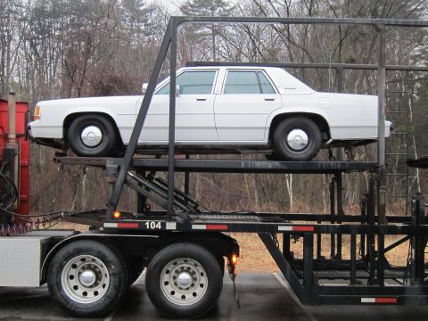 1991 Ford Crown Victoria LTD - A white 1990 Ford Crown Victoria LTD is transported on a car carrier.