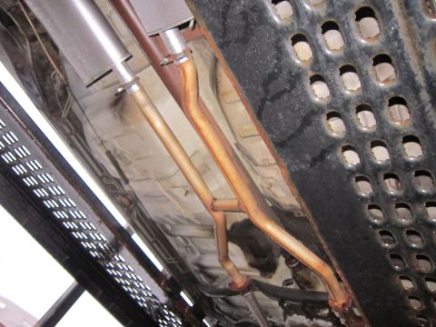 1991 Ford Crown Victoria LTD - Undercarriage view shows the dual exhaust system, including mufflers and pipes, with visible rust.