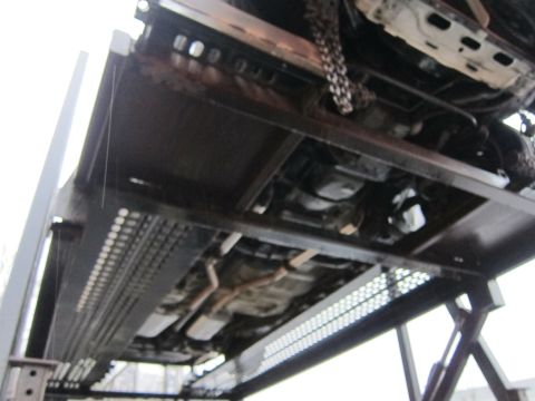 1991 Ford LTD Crown Victoria - The underside of a vehicle is shown being transported on a car carrier, with another vehicle above it.