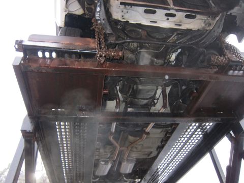 1991 Ford LTD Crown Victoria - The underside of a 1991 Ford Crown Victoria LTD is visible as it is transported on a trailer.