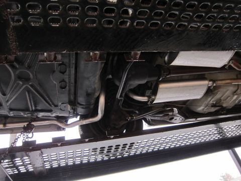 1991 Ford LTD Crown Victoria - The underside of a vehicle is visible, secured to a trailer with chains.