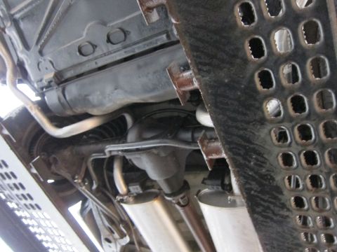 1991 Ford LTD Crown Victoria - Undercarriage view shows dual exhaust pipes and the rear differential of a vehicle.