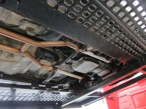 1991 Ford LTD Crown Victoria - Underside of a vehicle being transported on a car carrier, showing the exhaust and transmission components.