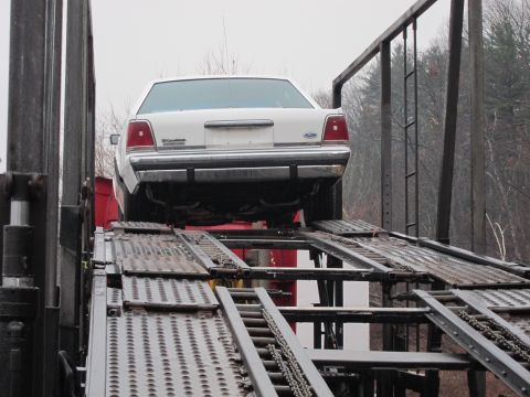 1991 Ford LTD Crown Victoria - A white 1991 Ford Crown Victoria LTD is being loaded onto a car carrier.