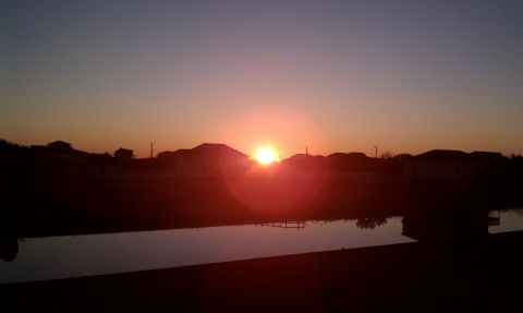 1979 Ford Bronco - Sunset over houses and a body of water with a faint reflection.