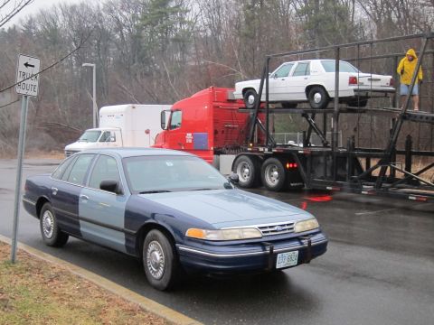 1991 Ford LTD Crown Victoria - A two-tone Ford Crown Victoria is parked on the side of the road near a car carrier truck.
