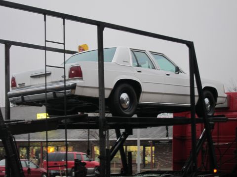 1991 Ford LTD Crown Victoria - A white 1990 Ford Crown Victoria LTD is transported on a car carrier.