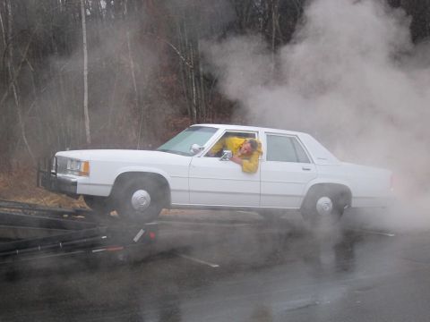 1991 Ford LTD Crown Victoria - A white 1991 Ford Crown Victoria LTD is seen from the side, with a person in a yellow jacket leaning out the driver's side window.