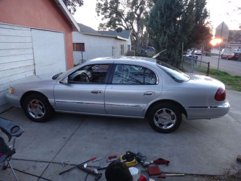 2000 Lincoln Continental - Silver 2000 Lincoln Continental parked in a driveway with tools on the ground.