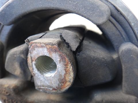 2003 Ford Taurus - Close-up of a damaged engine mount, showing wear and tear on the rubber and metal components.