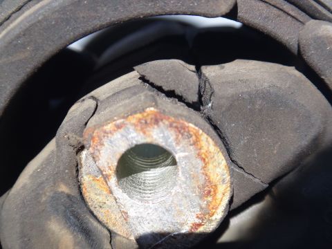 2003 Ford Taurus - Close-up of a damaged motor mount, showing significant cracking in the rubber and rust on the metal components.