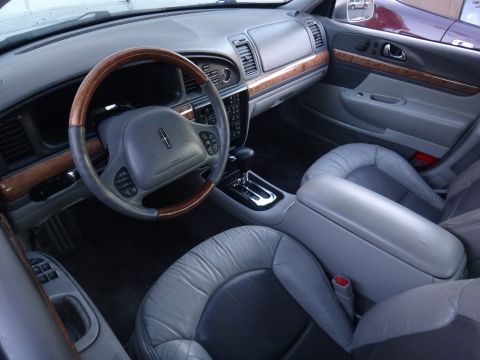 2000 Lincoln Continental - The interior of a 2000 Lincoln Continental features leather seats and wood trim accents.
