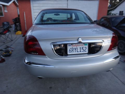2000 Lincoln Continental - The rear of a silver Lincoln Continental is visible, parked next to another vehicle.