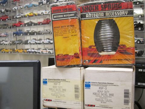 1991 Ford LTD Crown Victoria - Boxes of antenna accessories, including a shock spring, are displayed in front of shelves of model cars.