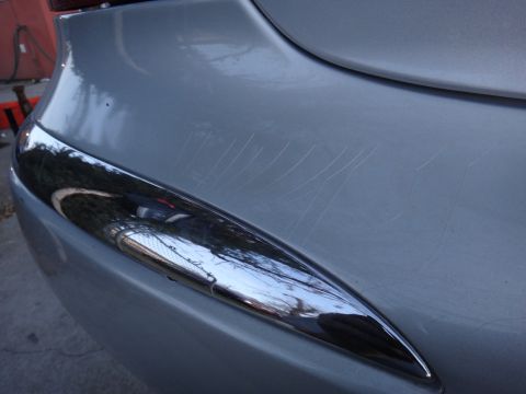 2000 Lincoln Continental - Scratched rear bumper with chrome accent trim.