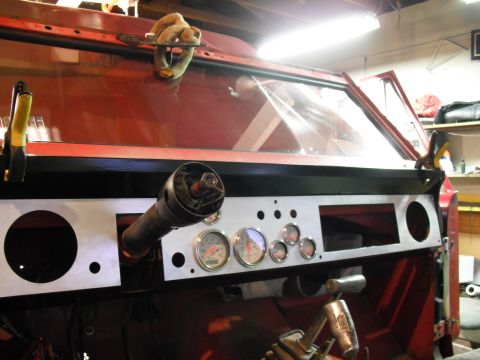 1968 Ford Bronco - The dashboard of a vehicle is being worked on, with gauges installed and openings for other components.