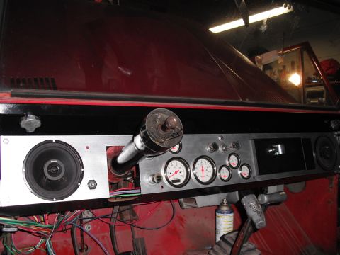 1968 Ford Bronco - Interior shot of a custom brushed-aluminum dash panel in a red vehicle under restoration, fitted with a set of white-faced aftermarket gaug…