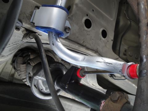 2003 Ford Taurus - Close-up view of a rear sway bar assembly, blue and silver bushings and red end links.