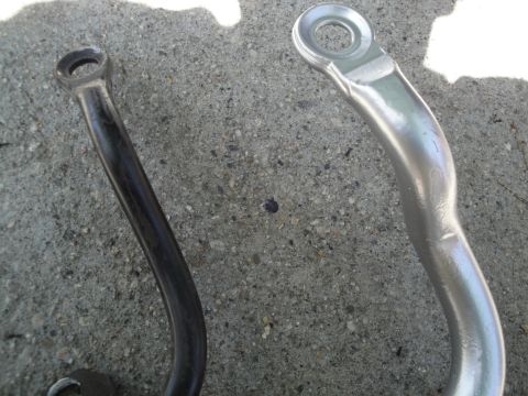 2003 Ford Taurus - Comparison of two sway bar end links, one with black coating and one with a silver finish.