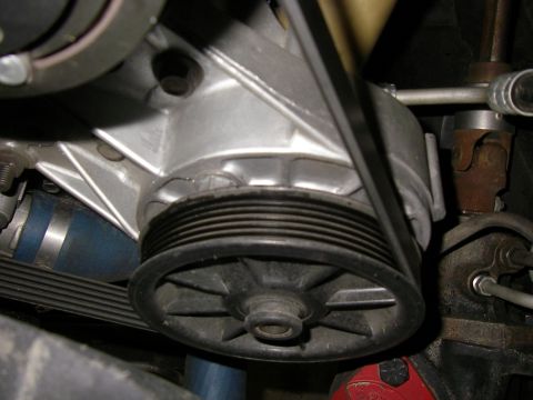 1990 Ford Bronco - Close-up view of an engine pulley system, showing the ribbed belt and associated components.