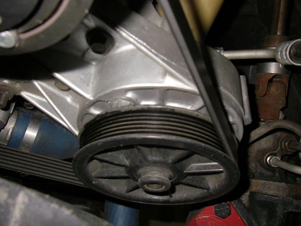 Engine pulley with ribbed belt and blue hose