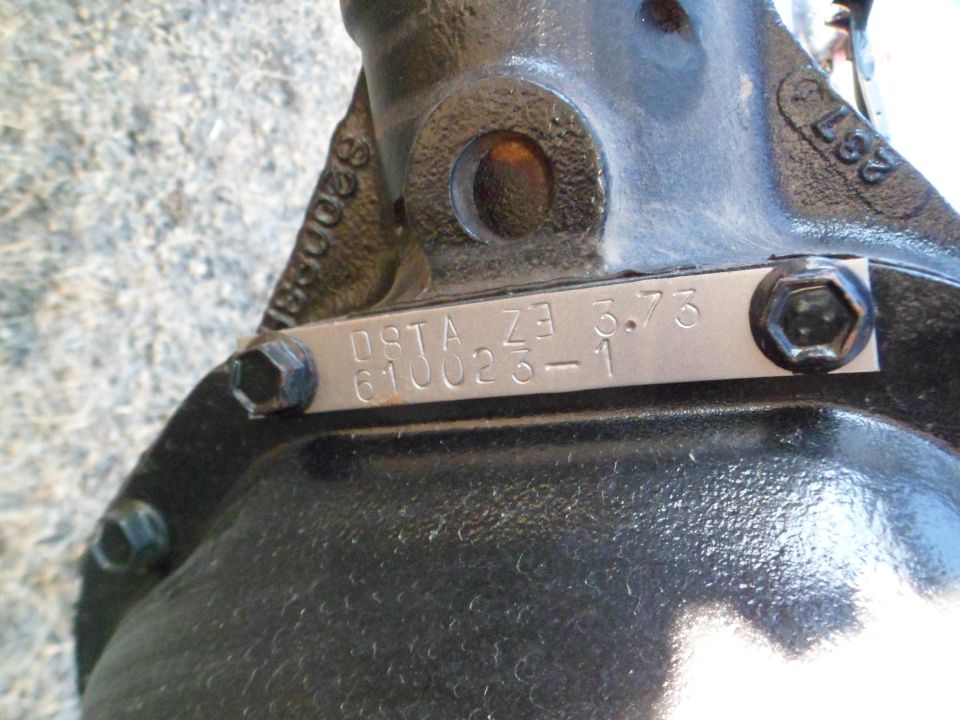 Close-up of a metal tag on a vehicle axle showing '08TA Z3 3.73 610025-1'