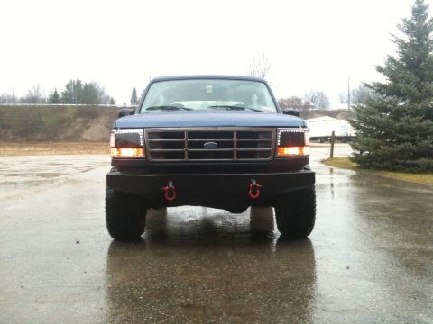 1996 Ford Bronco - Front view of a blue Ford truck with a custom bumper and updated lighting.