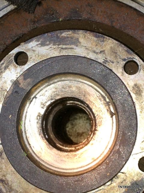 1979 Ford Bronco - A detailed view of a worn front hub assembly, showing signs of rust and accumulated grease.