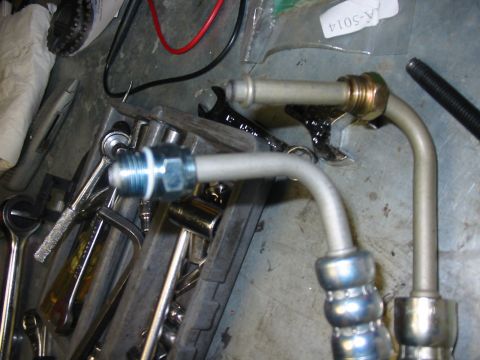 1992 Ford Bronco - Power steering lines and assorted tools are laid out on a workbench.